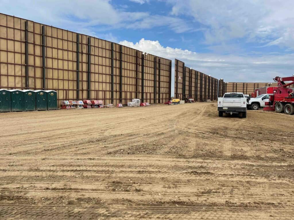 A sound-barrier wall assembled around a hydraulic fracturing site in the Denver-Julesburg Basin (DJ Basin) east of the Rocky Mountains in Colorado